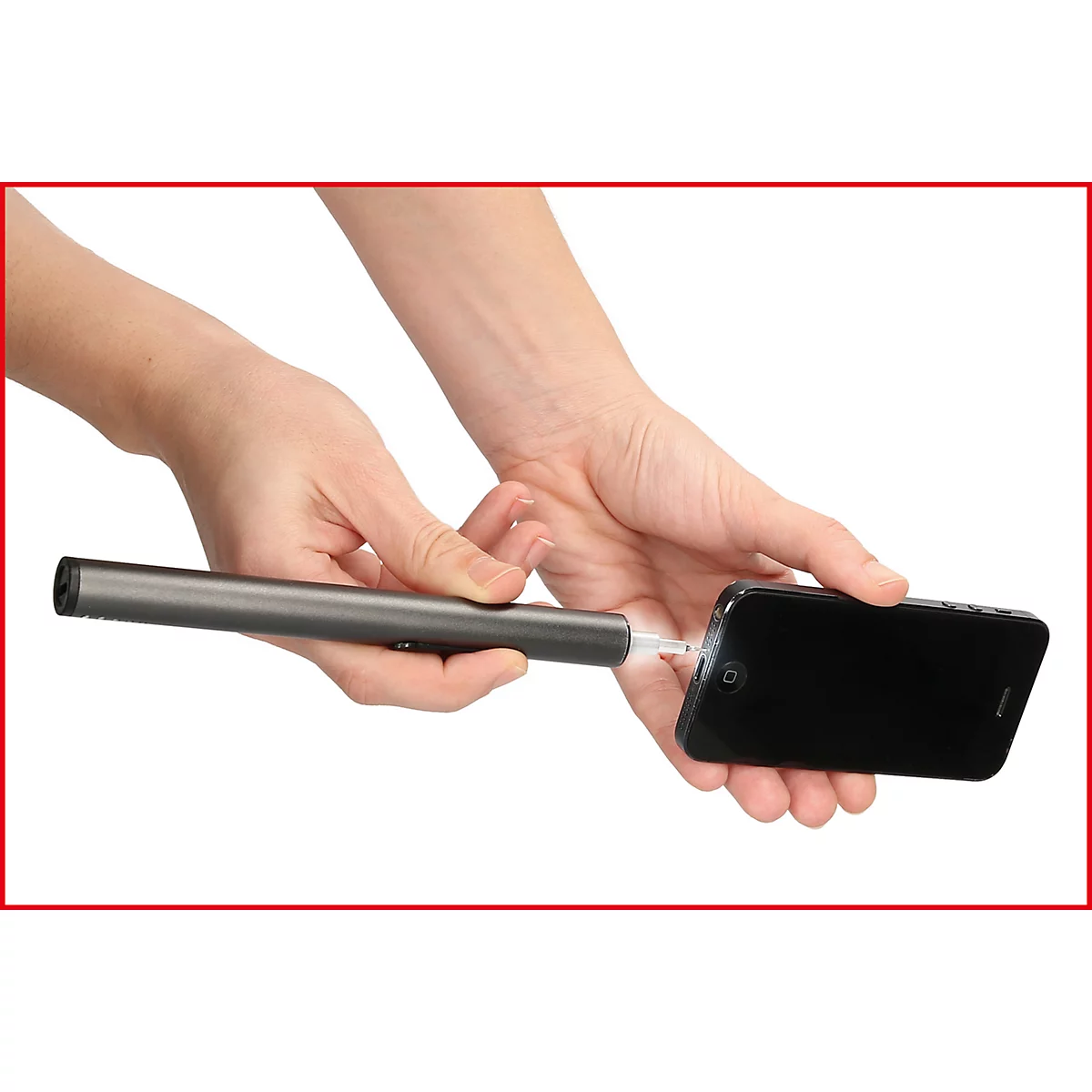 Person verbindet Stift-ähnliches Ladegerät mit einem schwarzen Smartphone. Beide Hände halten das Gerät.